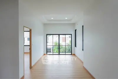 Spacious and bright living room with large windows and balcony access, perfect for modern living.