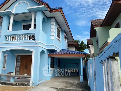 Charming blue two-story house with balcony and spacious driveway