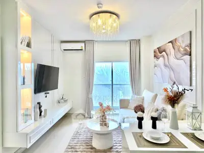 Elegant living room with modern decor, stylish chandelier, and cozy seating area, perfect for relaxation.