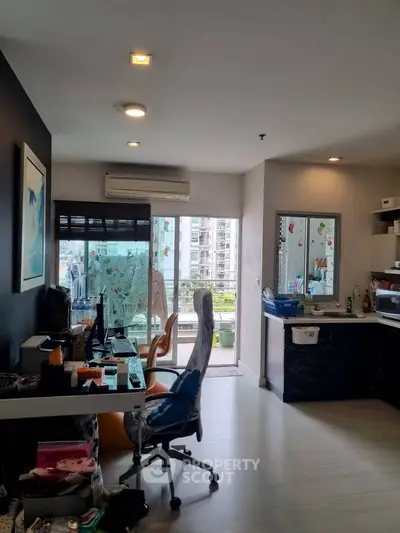 Modern apartment interior with study area and balcony view, featuring sleek design and ample natural light.