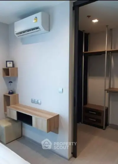 Modern bedroom with air conditioning and walk-in closet in stylish apartment.