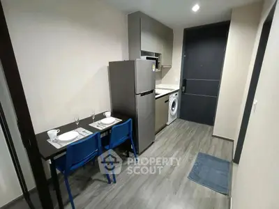 Modern kitchen with dining area, featuring sleek appliances and stylish decor, perfect for urban living.