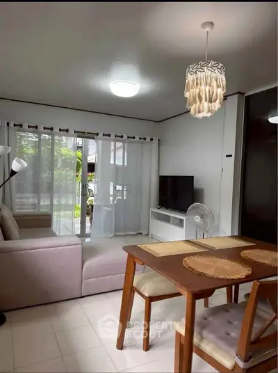 Cozy living room with modern decor, large window, and stylish furniture in a bright, inviting space.