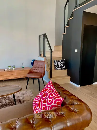 Stylish modern living room with leather sofa and chic staircase