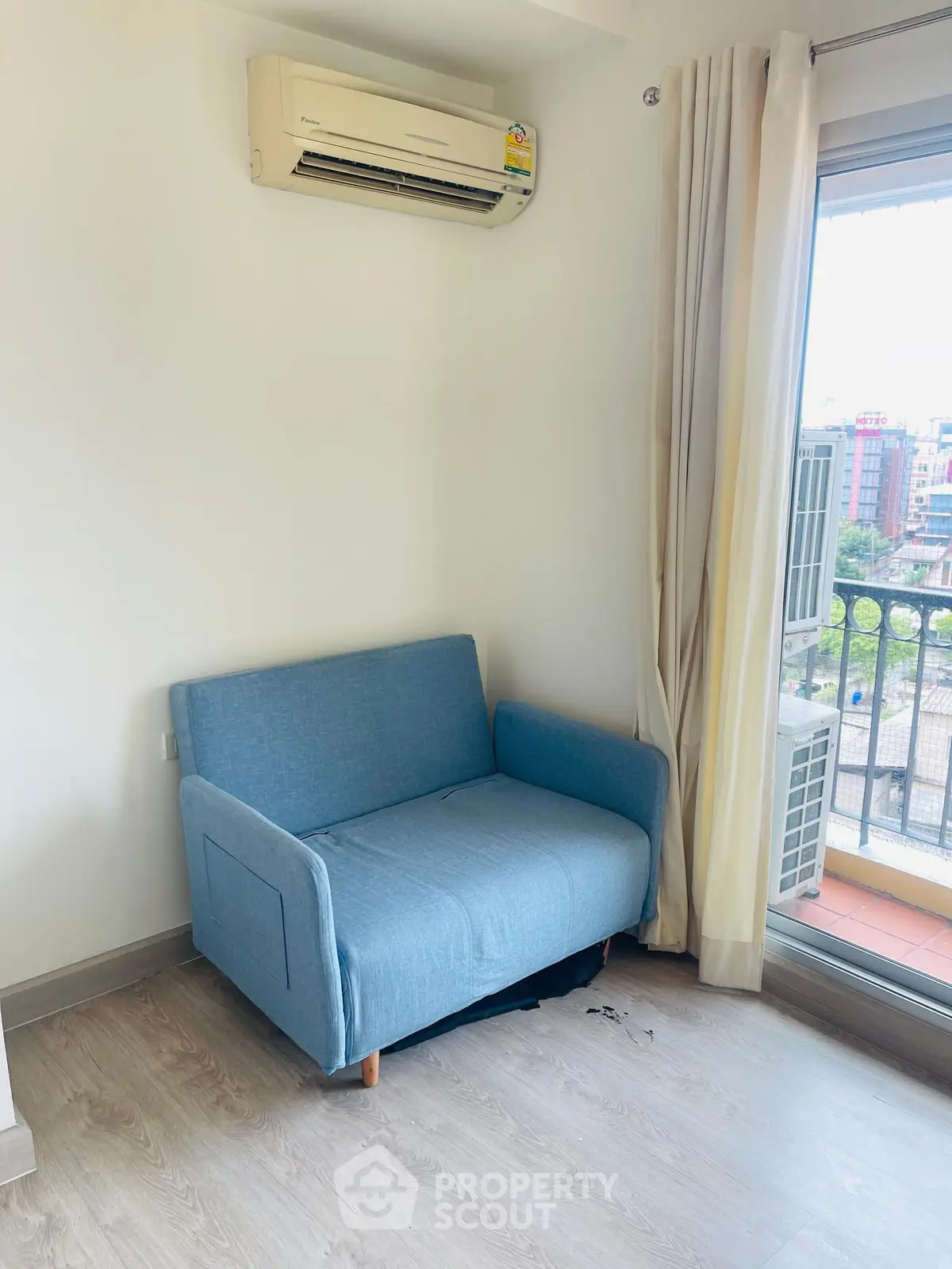 Cozy corner with blue sofa and air conditioning in bright apartment