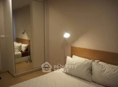 Cozy bedroom with modern decor and mirrored wardrobe, perfect for relaxation.