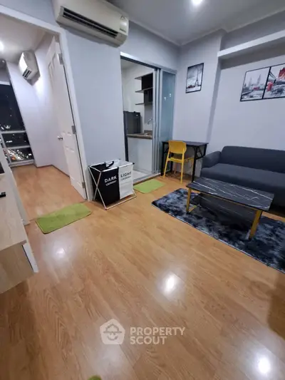 Modern living room with wooden flooring, cozy sofa, and stylish decor in a high-rise apartment.