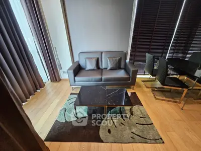 Modern living room with stylish sofa and dining area, featuring elegant decor and natural light.
