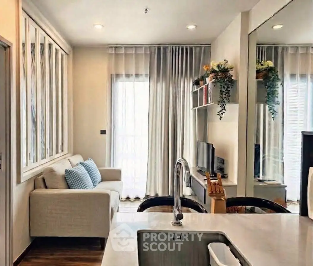 Modern living room with cozy sofa, stylish decor, and natural light from large windows.
