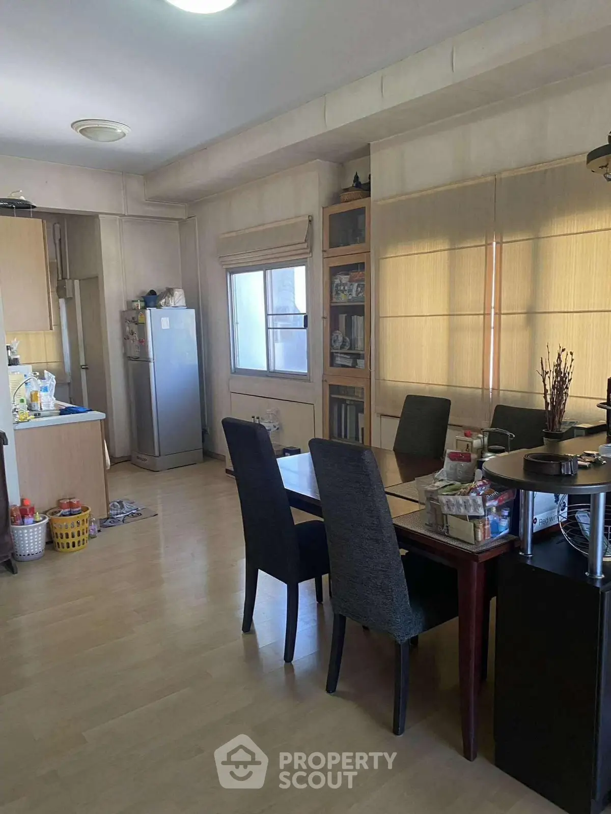 Spacious dining area with natural light and modern kitchen appliances in a cozy apartment.