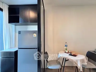 Modern kitchen and dining area with sleek fridge and cozy table setting.