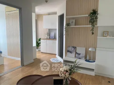Modern living room with stylish decor and wooden flooring, featuring open layout and natural light.