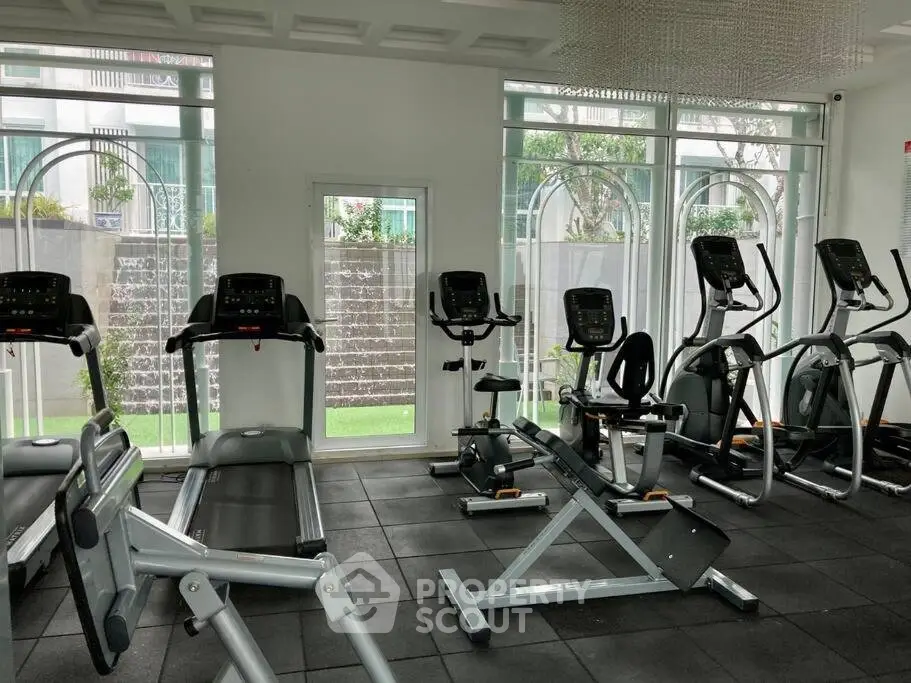 Modern gym with state-of-the-art exercise equipment and large windows for natural light.