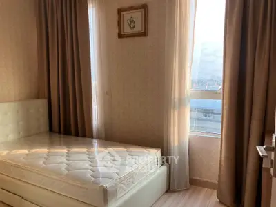 Cozy bedroom with natural light and elegant curtains in a modern apartment.