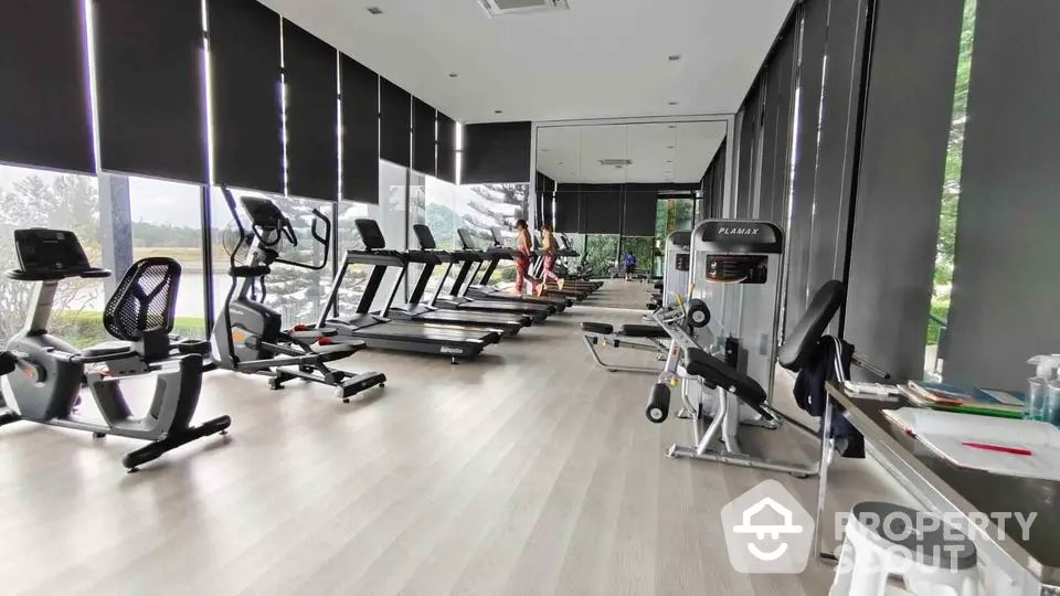 Modern gym with state-of-the-art equipment and large windows offering scenic views.