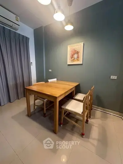 Modern dining area with wooden table and chairs, stylish lighting, and elegant wall art.