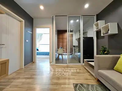 Modern open-plan living room with sleek kitchen and cozy bedroom view.