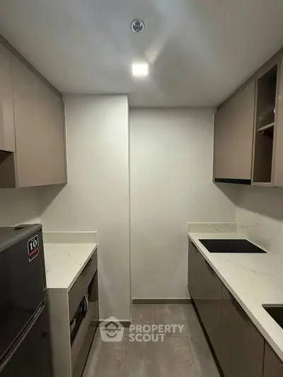 Modern kitchen with sleek cabinetry and built-in appliances in a compact layout.