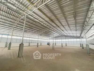 Spacious industrial warehouse with high ceilings and metal structure, ideal for storage or manufacturing.