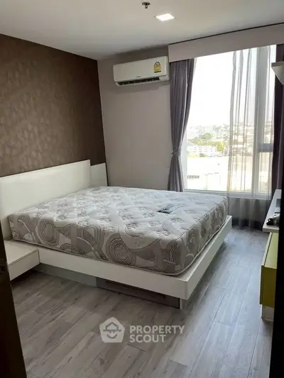 Modern bedroom with large window and stylish decor in urban apartment