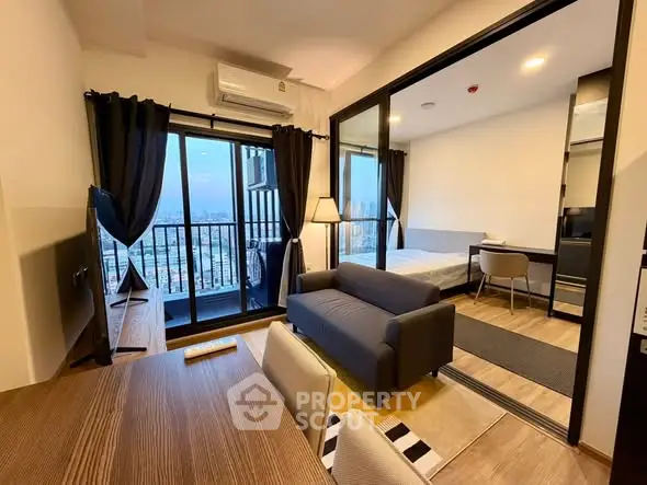 Modern studio apartment with balcony and city view, featuring sleek furnishings and open layout.