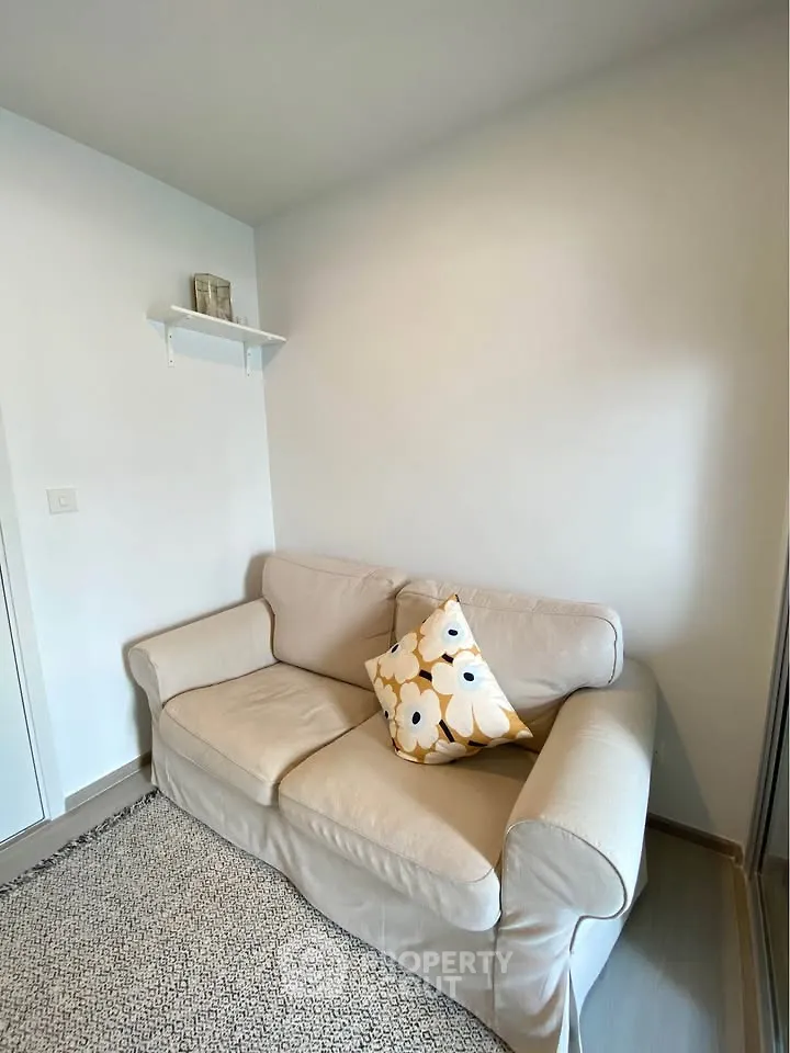 Cozy small living room with beige sofa and decorative cushion
