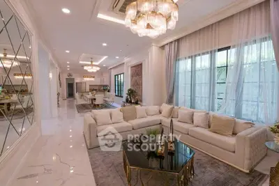 Luxurious open-plan living room with elegant chandelier and plush sofa in a modern home.
