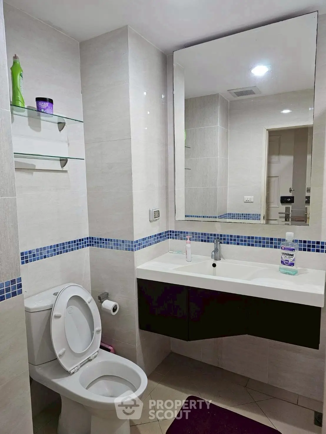 Modern bathroom with sleek fixtures and large mirror in a contemporary apartment.
