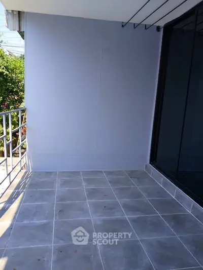 Spacious balcony with modern tiles and railing, perfect for outdoor relaxation.