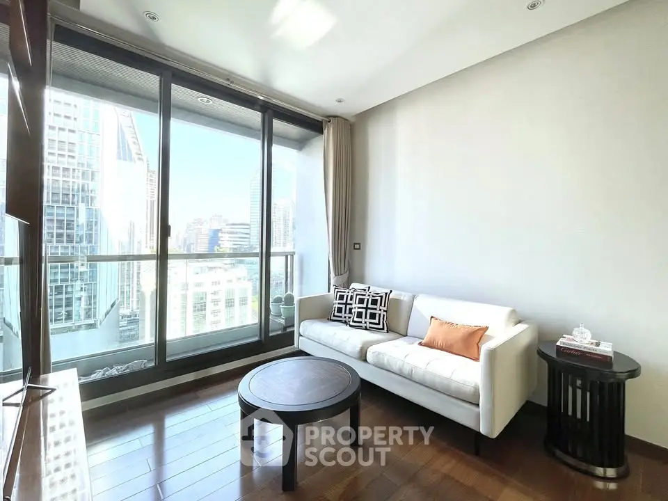 Modern living room with large windows and city view, featuring stylish furniture and hardwood floors.