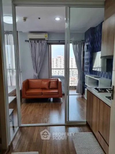 Modern apartment with open layout, featuring a cozy living area and compact kitchen, city view.