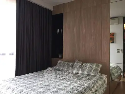 Modern bedroom with stylish wooden paneling and cozy bedding in a contemporary apartment.