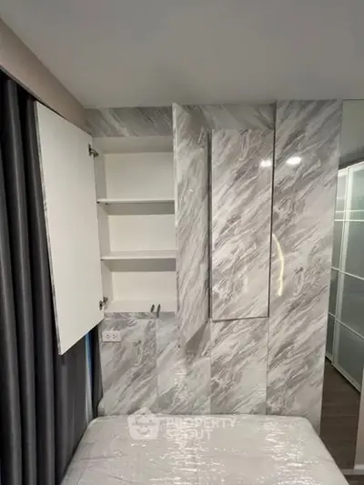 Modern bedroom with sleek marble wall design and built-in storage