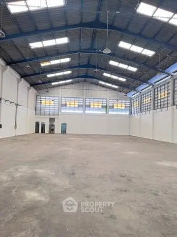 Spacious industrial warehouse with high ceilings and ample natural light.