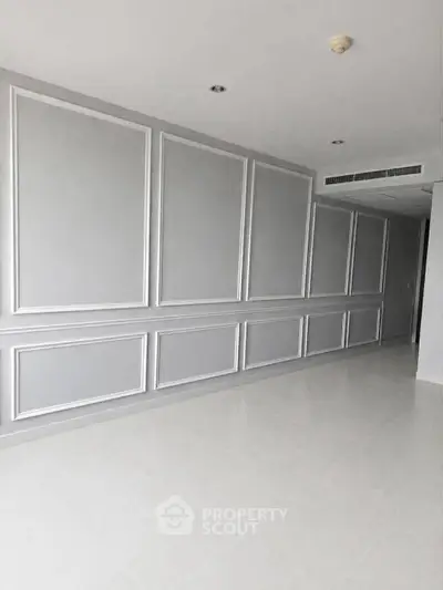 Spacious modern interior with elegant wall paneling and sleek flooring, perfect for customization.