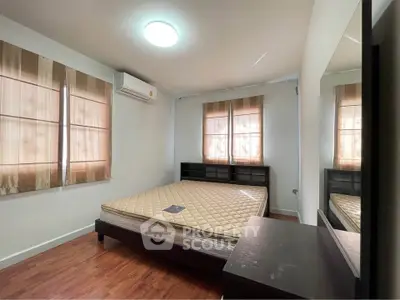 Spacious bedroom with natural light and modern furnishings, perfect for comfortable living.
