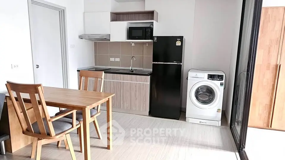 Modern kitchen with dining area, featuring sleek appliances and stylish wooden furniture.