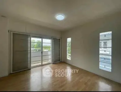 Spacious empty room with large windows and balcony access, perfect for customization.