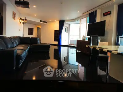 Luxurious living room with sleek black flooring and modern furnishings in a high-end apartment.
