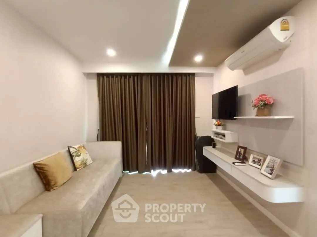 Modern living room with sleek design and cozy ambiance, featuring a wall-mounted TV and stylish decor.