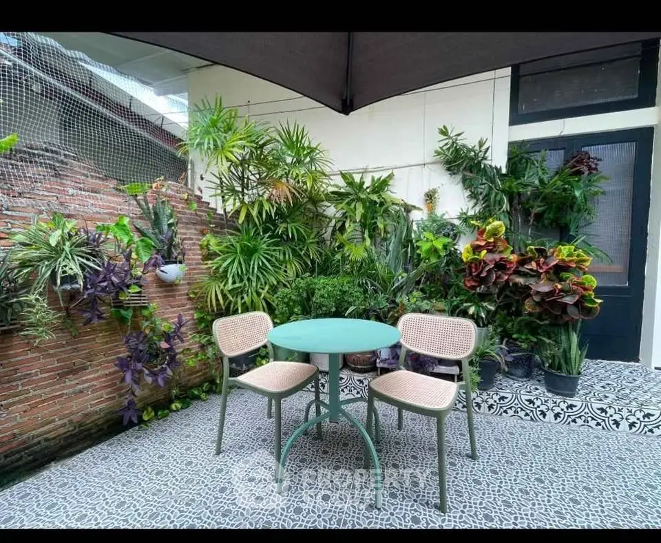Charming garden patio with lush greenery and stylish outdoor seating, perfect for relaxation and entertaining.