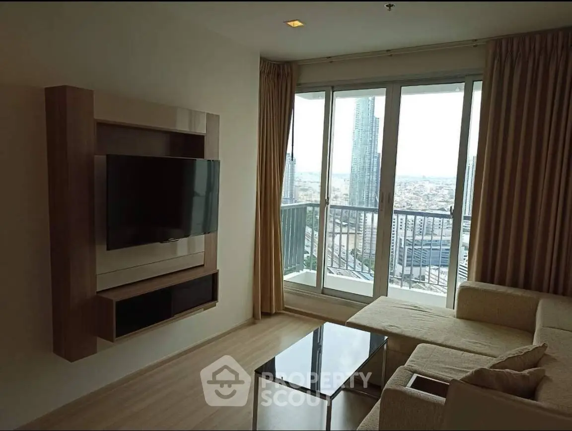 Modern living room with city view, featuring a wall-mounted TV and cozy seating area.