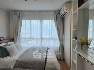 Cozy bedroom with city view, featuring a comfortable bed and elegant decor.
