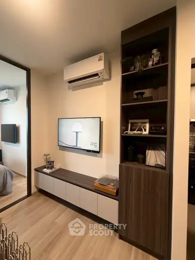 Modern living room with sleek furniture and wall-mounted TV, featuring a stylish air conditioning unit.