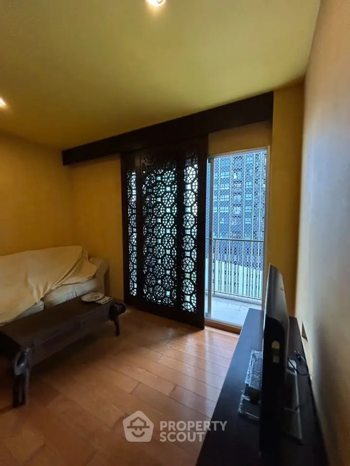 Cozy living room with intricate wooden panel and balcony view