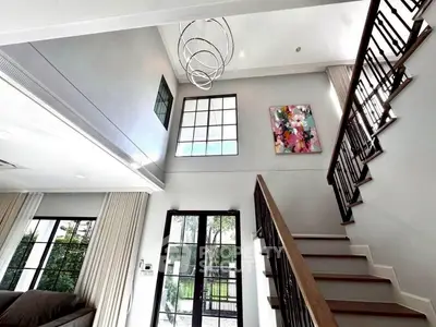 Stunning modern living room with high ceilings and elegant staircase