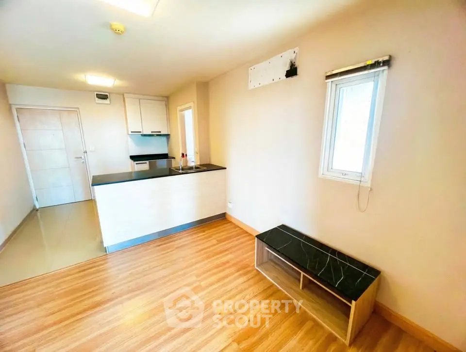 Modern open-plan living room with sleek kitchen and wooden flooring, perfect for contemporary living.