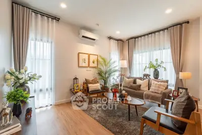 Elegant living room with modern decor, cozy seating, and natural light.
