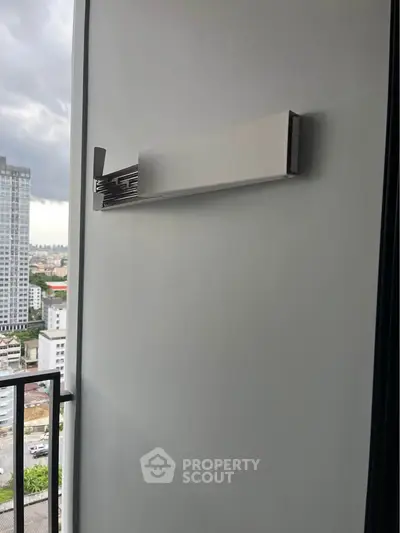 Modern balcony with sleek wall-mounted drying rack and city view, perfect for urban living.