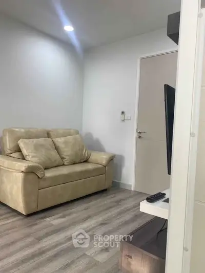 Cozy living room with beige sofa and modern decor, perfect for relaxation and entertainment.